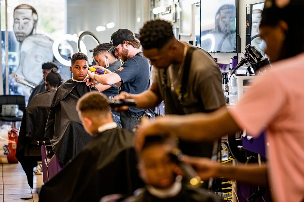 Un salon de barbier animé, un barbier au travail à chaque fauteuil.